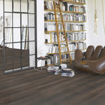 donkergrijze houtlook vloer met brede planken en subtiele houtnerfstructuur in moderne leesruimte met houten ladder en bruin leren zitzak fauteuil