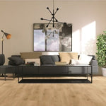 lichte vloer in naturel beige eiken met brede planken en subtiele houtnerfstructuur in een lichte, modern ingerichte woonkamer met donkergrijze bank en beige kussens