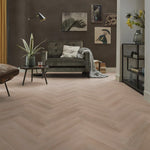 licht beige visgraatvloer met subtiele houtstructuur en brede planken in moderne woonkamer met antraciet bank en planten op houten salontafel