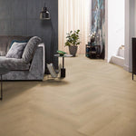lichte beige eiken vloer in visgraat patroon met subtiele houtstructuur in moderne woonkamer met grijs stoffen bank en zwarte lamp