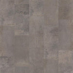 Grijze tegelvloer met grote rechthoekige tegels in verschillende tinten grijs en beige met een subtiel golvend en korrelig oppervlak en matte structuur.