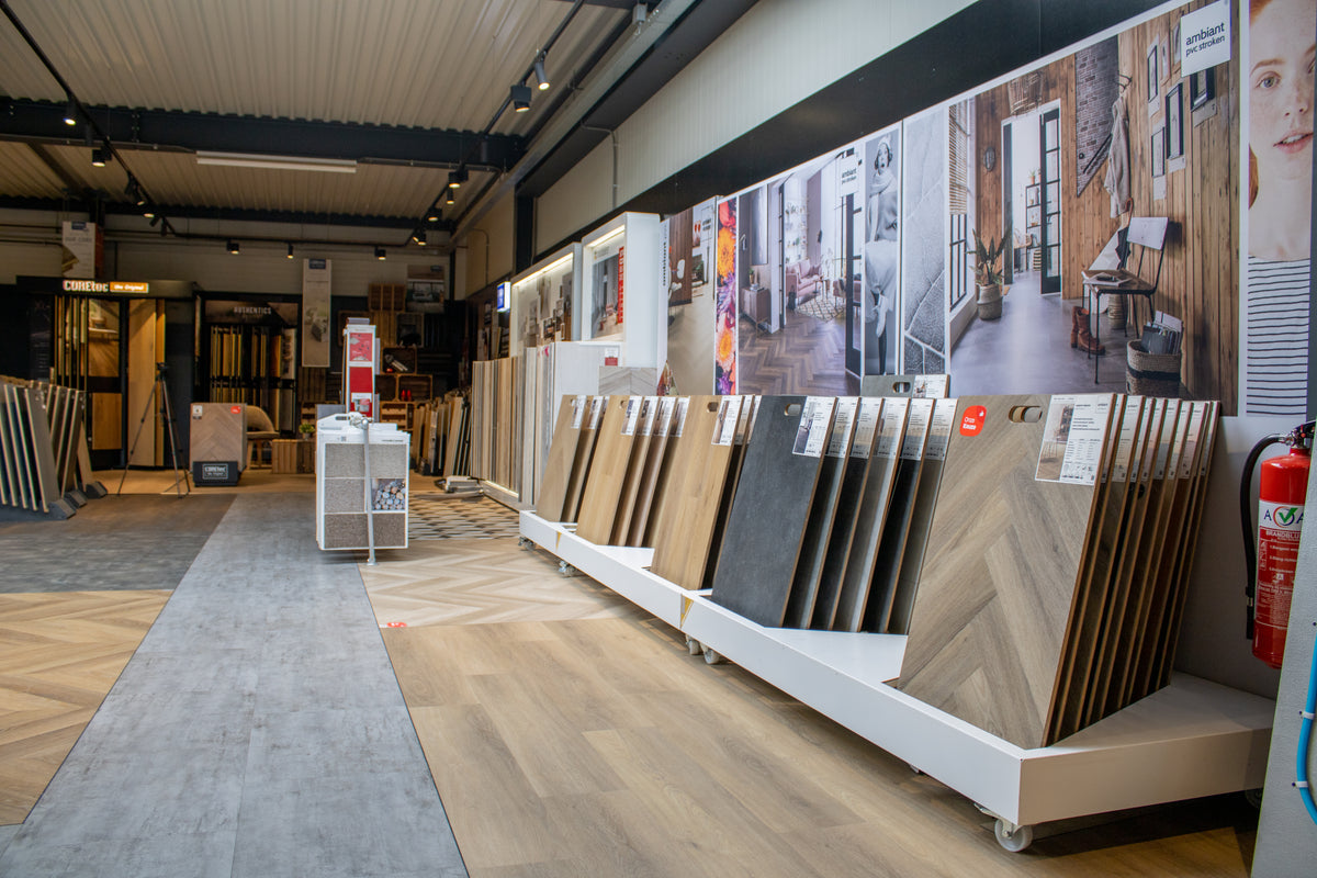 Ruime showroom met laminaat, PVC en houten vloeren stalen