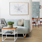 licht eiken vloer met brede planken in visgraatpatroon gecombineerd met modern interieur met zacht blauwgrijze bank en houten bijzettafel met wit metalen frame