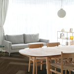 donkerbruin eiken visgraatvloer met matte structuur in lichte woonkamer met grijs stoffen bank en licht houten eetkamertafel met bijpassende stoelen