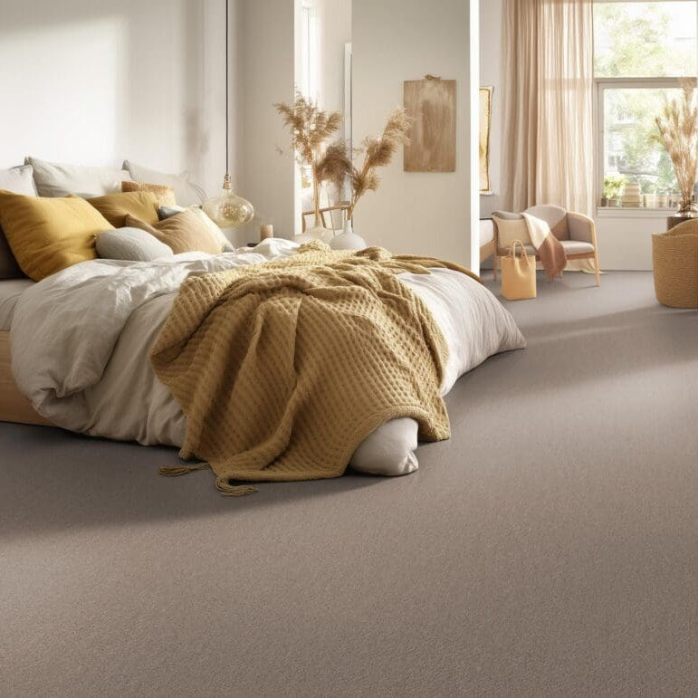 taupe gekleurd tapijt met fijne, effen structuur in een moderne slaapkamer met beige en mosterdkleurige accenten
