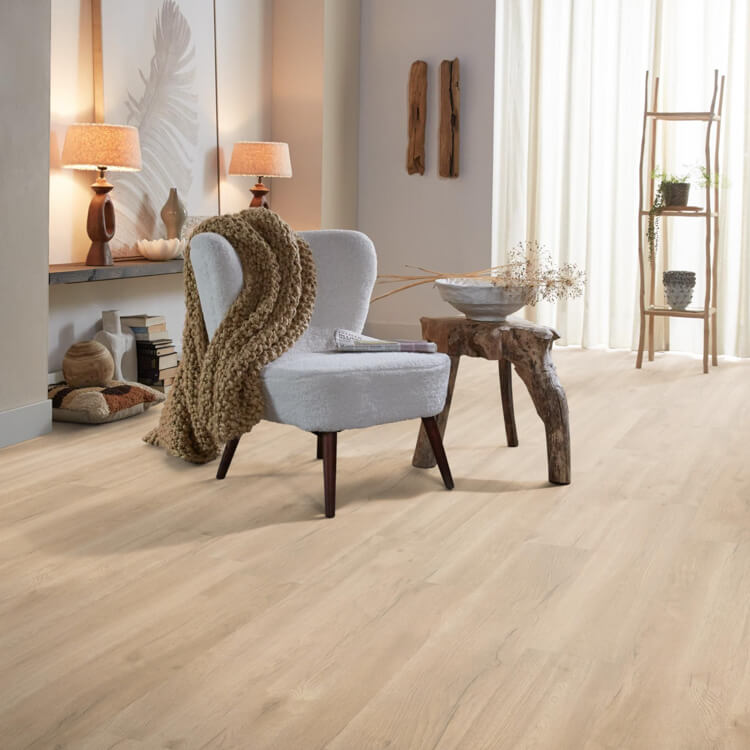 licht beige eiken vloer met brede planken in naturel houtstructuur in een warme, lichte woonkamer met een lichtgrijze stoel en houten bijzettafel