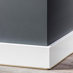 Strakke brede witte plint van glad hout tegen een donkergrijs geschilderde muur met een laminaatvloer in lichtbruin eiken decor zichtbaar onderaan.