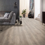 licht beige eiken vloer met brede planken en subtiele houtnerven in moderne woonkamer met grijs stoffen bank en zwarte bijzettafel