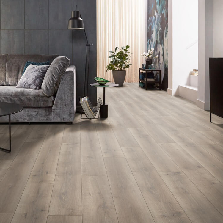 licht beige eiken vloer met brede planken en subtiele houtnerven in moderne woonkamer met grijs stoffen bank en zwarte bijzettafel