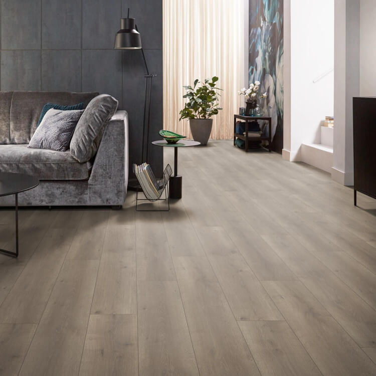 licht grijs bruine vloer met brede planken in houtstructuur, gecombineerd met modern interieur met grijze stoffen bank en zwarte metalen meubels