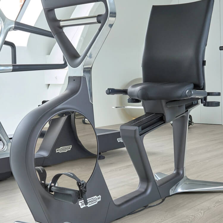 lichte eiken vloer met brede planken en subtiele houtnerfstructuur in een moderne fitnessruimte met zwarte en grijze fitnessapparaten