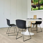 licht beige eiken vloer met brede planken in rechte rij, modern interieur met wit ovale tafel en zwarte metalen stoelen met kunststof zitting