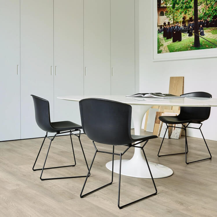licht beige eiken vloer met brede planken in rechte rij, modern interieur met wit ovale tafel en zwarte metalen stoelen met kunststof zitting
