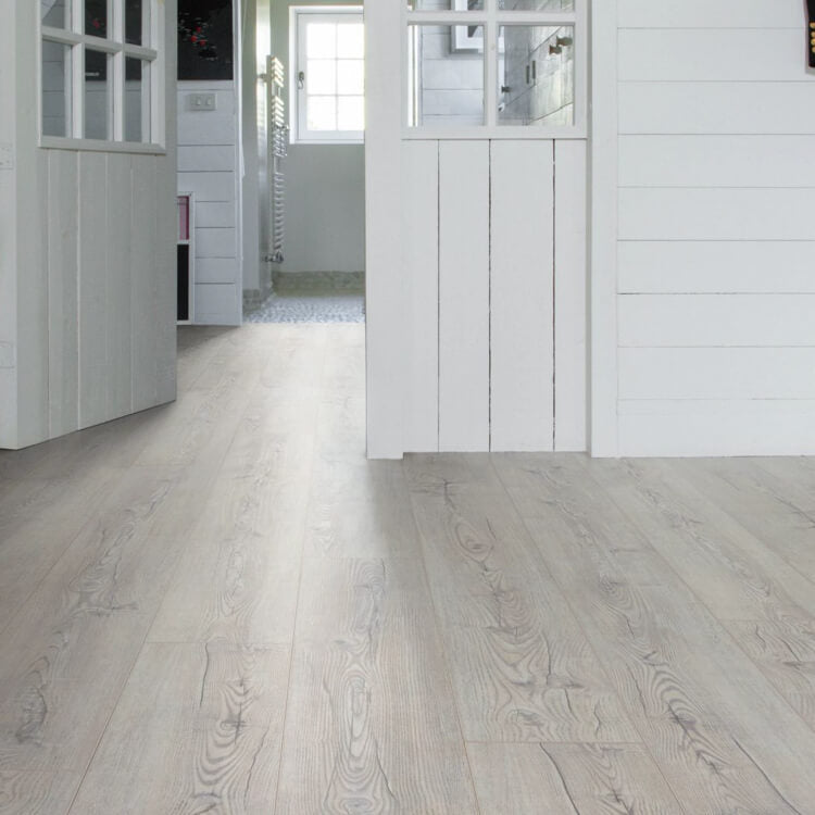 lichte grijs eiken vloer met brede planken en duidelijke houtnerfstructuur in een lichte, natuurlijke tint in een ruime, witte interieuromgeving