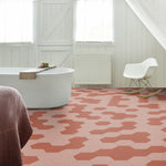 Hexagonale tegelvloer in een patroon met afwisselend terracotta rood en zacht roze hexagon tegels in een lichte, goed verlichte badkamer met witte wanden, witte vrijstaande badkuip en wit modern schommelstoel.