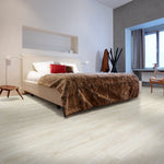 lichte eiken vloer met brede planken en subtiele houtnerfstructuur in slaapkamer met beige bed en bruin bontplaid