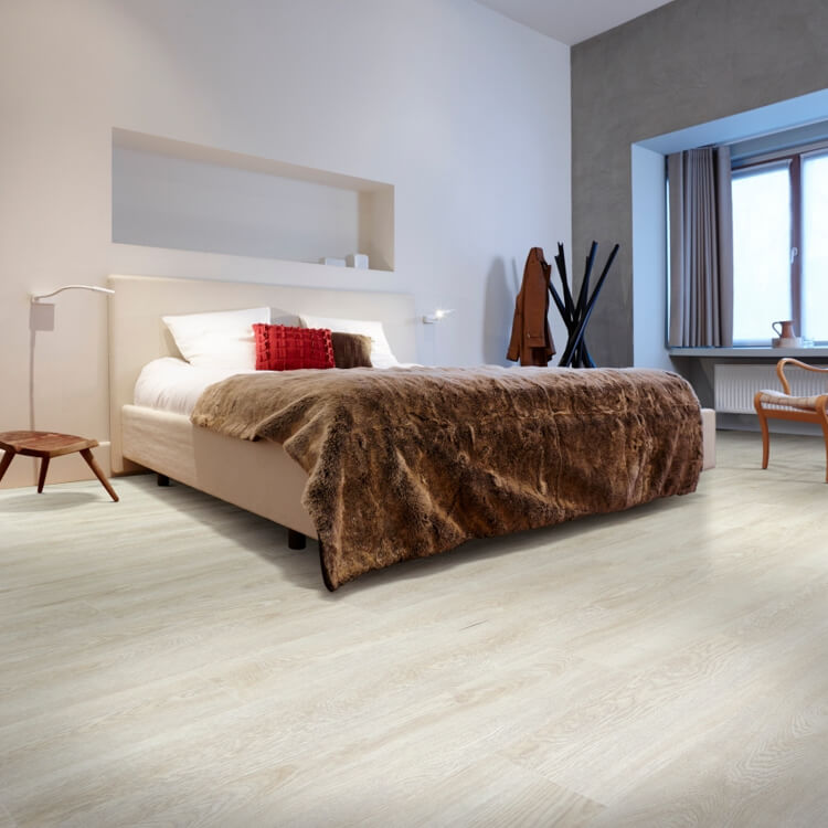 lichte eiken vloer met brede planken en subtiele houtnerfstructuur in slaapkamer met beige bed en bruin bontplaid