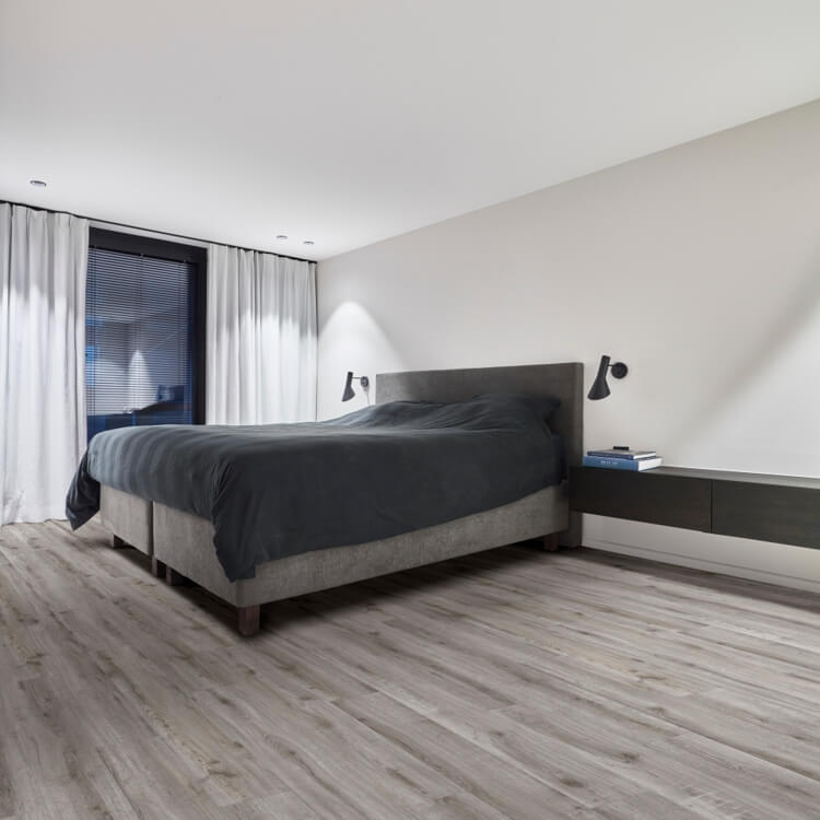 licht grijs eiken vloer met brede planken in een minimalistische slaapkamer met een grijs bed en witte wanden