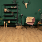 lichte eiken vloer met brede planken en een natuurlijke houtnerfstructuur in een warme zandkleurige tint, gecombineerd met groene muur en moderne woonaccessoires