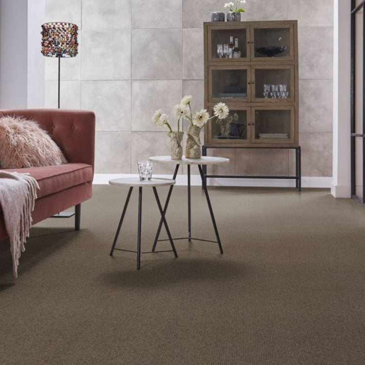 zachte bruine tapijtvloer met fijne, dichtgeweven structuur in moderne woonkamer met donkerroze bank en beige-witte ronde salontafels