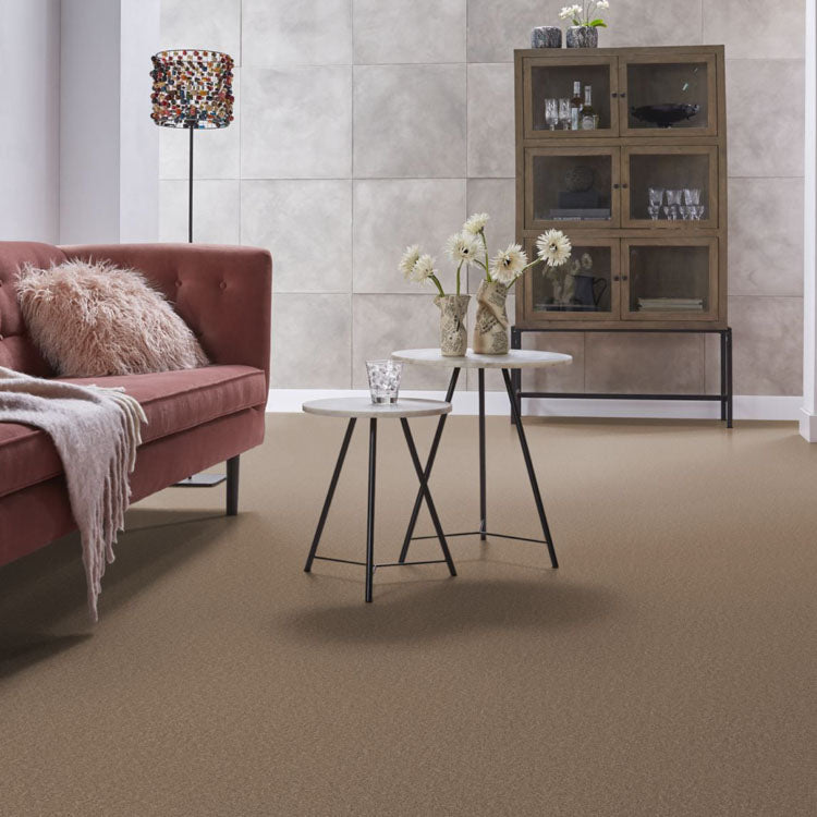 lichte beige tapijtvloer met fijne structuur in moderne woonkamer met oudroze fluwelen bank en wit marmer look ronde bijzettafels