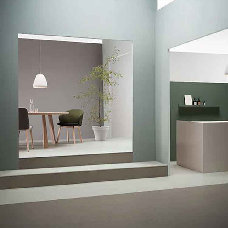 lichte vloer met brede planken in een neutrale taupe kleur, moderne ruimte met traptreden en minimalistisch interieur met een houten tafel en verschillende groene en bruine stoelen naast een witte plantenpot met groene plant