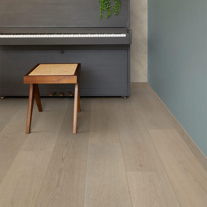 licht eiken vloer met brede planken in een subtiele houtstructuur, gecombineerd met een houten kruk met gevlochten zitting voor een sfeervolle ruimte naast een zwart houten piano