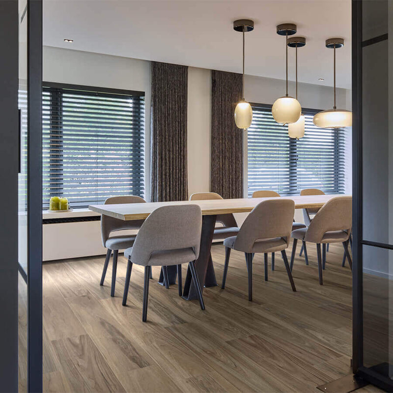 licht bruin eiken vloer met natuurlijke houtnerf structuur en brede planken in moderne eetkamer met grijs stoffen stoelen en minimalistische hanglampen