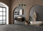donkergrijze tegelvloer met grote matte tegels in antraciet met subtiel golvend streeppatroon, moderne badkamer met beige bakstenen muren en boogvormige doorgangen