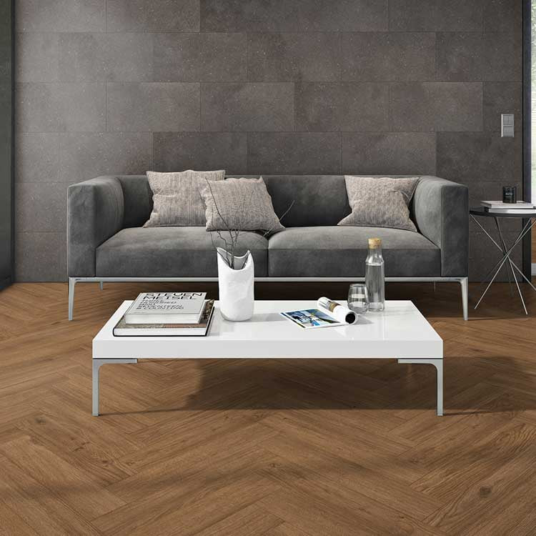 licht eiken visgraatvloer met smalle planken in moderne woonkamer met grijs stoffen bank en witte salontafel