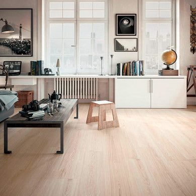 lichte eiken vloer met brede planken en subtiele houtnerfstructuur in lichte, natuurlijke kleurstelling in moderne woonkamer met wit meubel en zwarte accenten