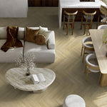licht beige eiken vloer met visgraatpatroon, brede planken, moderne woonkamer met beige bank, houten stoelen en ovale marmerkleurige salontafel