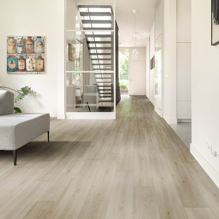 lichte eiken vloer met brede planken en een subtiele houtnerfstructuur in een natuurlijke, lichte kleurtoon in een moderne woonkamer met grijze meubels en veel daglicht