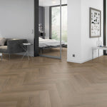 licht beige eiken vloer in visgraat patroon met matte afwerking in een moderne woonkamer met grijs meubel en witte muren