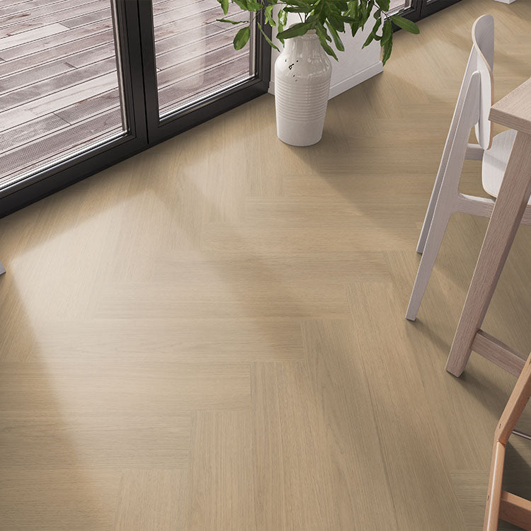 licht eiken vloer met visgraat patroon en fijne houtnerf structuur in een moderne lichte interieur setting naast een groot raam en een witte vaas met groene plant