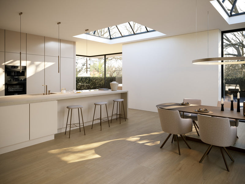 lichte vloer met brede planken in licht eiken met subtiele houtnerfstructuur in een moderne keuken met wit en beige meubels en veel natuurlijk licht door dakramen en grote ramen