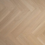 licht eiken visgraatvloer met een fijne houtnerf en matte structuur, brede planken met subtiele kleurvariaties in beige tinten