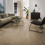 licht beige eiken vloer met brede planken en subtiele houtnerfstructuur in moderne woonkamer met groene stoffen bank en metalen salontafel
