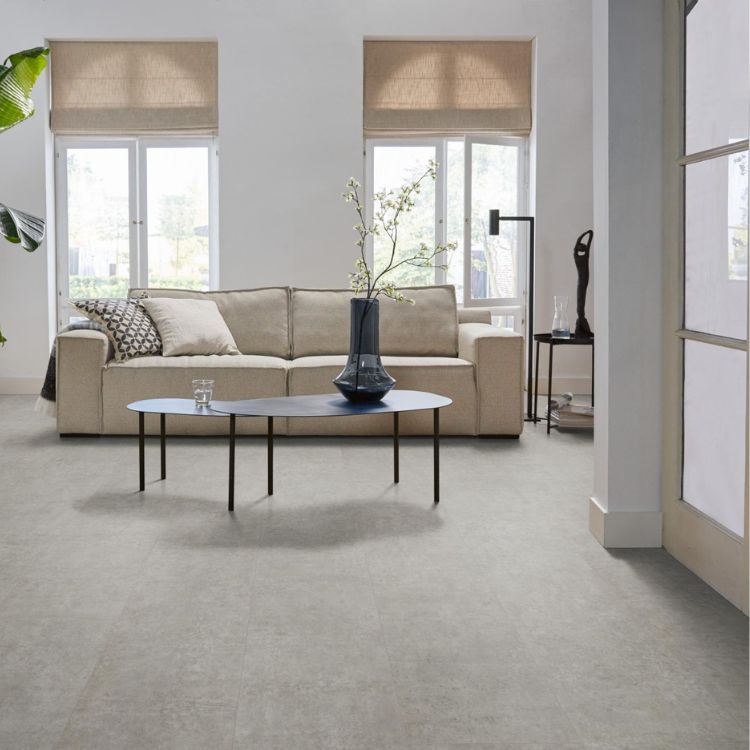 lichtgrijze tegelvloer met grote tegels en een subtiel golvend streeppatroon, in een moderne woonkamer met beige bank en zwarte ovale salontafel