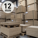 Stapels van 12 mm dikke spaanplaatplaten met grof gestructureerd oppervlak, opgeslagen in een magazijn op houten pallets.