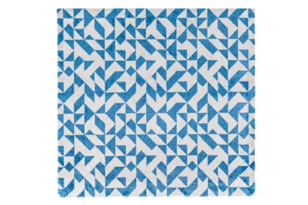blauw wit tapijt met geometrisch patroon van kleine driehoeken en vierkanten in een herhalend motief