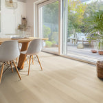 lichte beige eiken vloer met brede planken en subtiele houtstructuur in moderne eetkamer met grote glazen schuifdeuren naar tuin