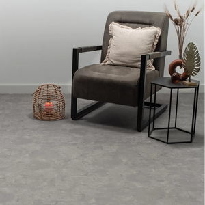 grijs tegelvloer met grote tegels in betonstructuur en licht varierend patroon in asgrijs en taupe tinten