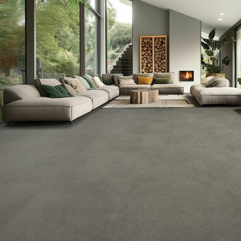 donkergrijze tegelvloer met subtiele structuur en matte afwerking in ruime woonkamer met grote lichtinval, beige en groentinten banken en houten salontafel in boomstamdesign