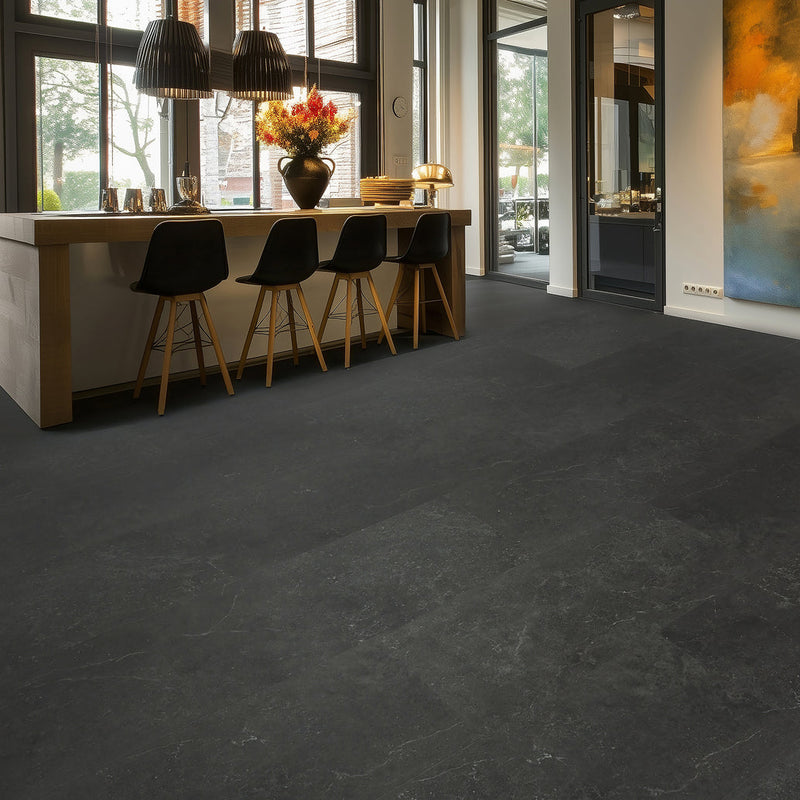 donkergrijze tegelvloer met grote tegels en subtiel golvend streeppatroon in moderne lichte woonkamer met houten bar en zwarte barkrukken