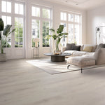 Lichte beige eiken vloer met brede planken en subtiele houtnerfstructuur in een moderne woonkamer met grote witte ramen.