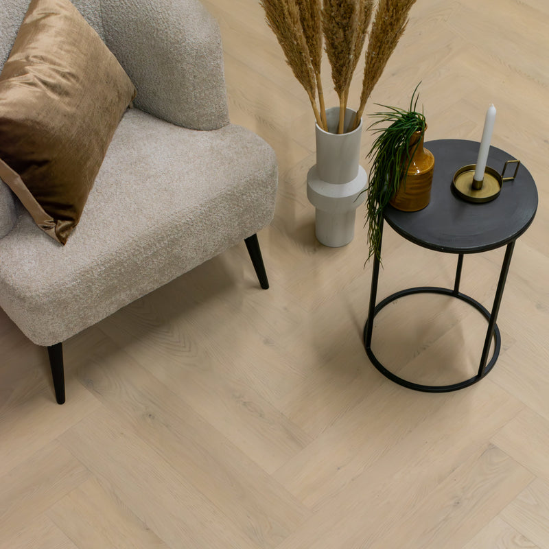 Lichte eiken visgraatvloer met een subtiele, natuurlijke houtstructuur en brede planken in een lichte beige eikenkleur.
