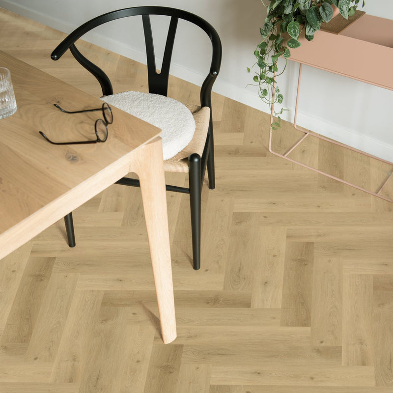licht eiken vloer in visgraatpatroon met fijne houtstructuur naast zwart houten designstoel en licht houten tafel