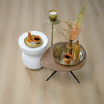 Licht beige eiken vloer met subtiele houtstructuur en brede planken, sfeervol ingericht met groene en oranje keramische accessoires en gedroogde bloemen op ronde tafels.
