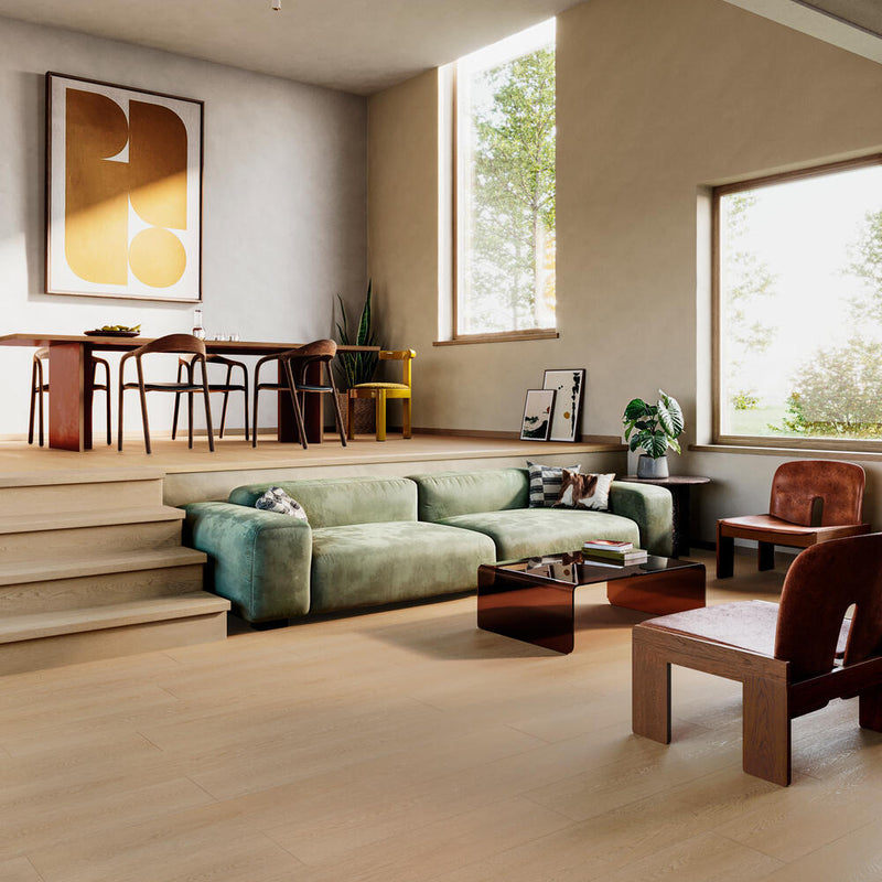 lichte vloer in brede planken met licht eiken houtstructuur in een modern ingerichte woonkamer met groene stoffen bank, bruine houten stoelen en grote ramen
